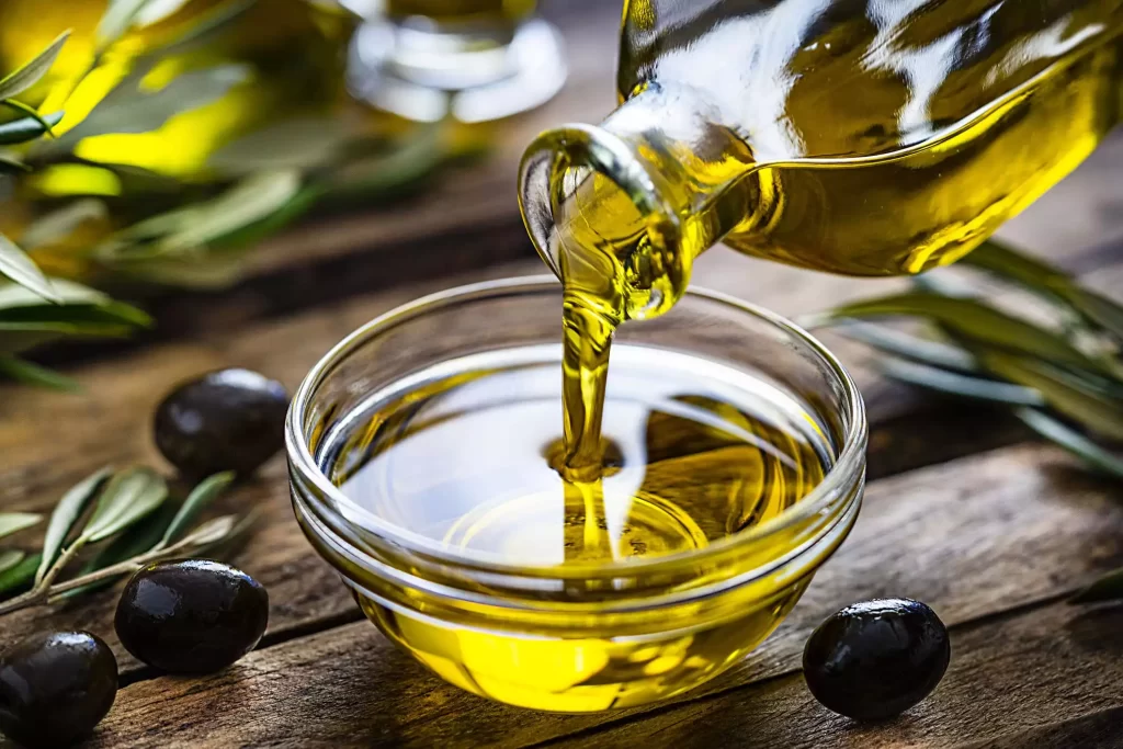 Olio extravergine di oliva evo che viene versato in una ciotolina